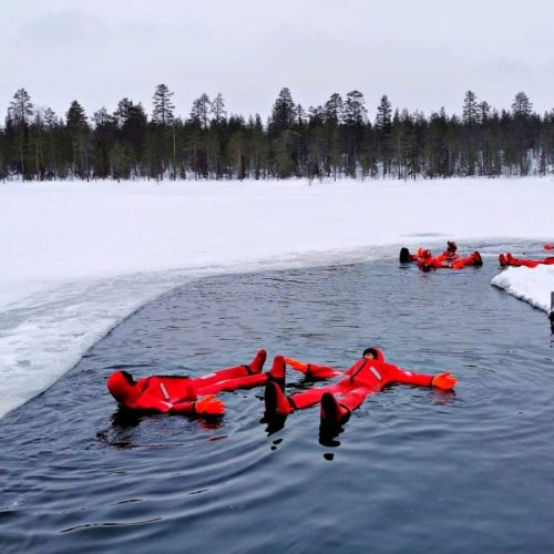Ice-Floating-Norway άνθρωποι ντυμένοι με θερμικές στολές επιπλέουν σε παγωμένη λίμνη στο Τρόμσο