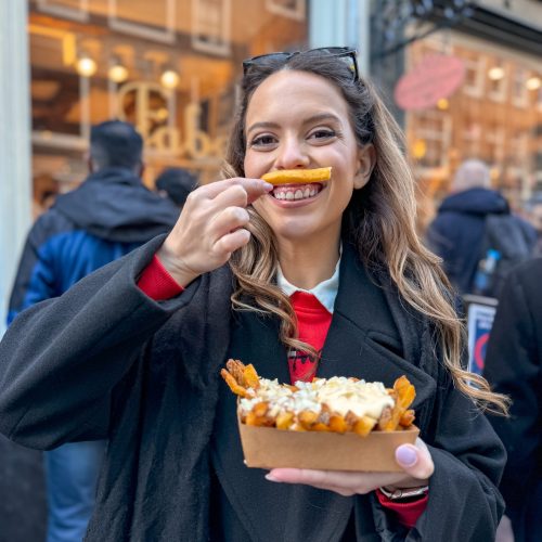 frenc-fries-amsterdam κορίτσι τρώει τηγανητές πατάτες στο Άμστερνταμ