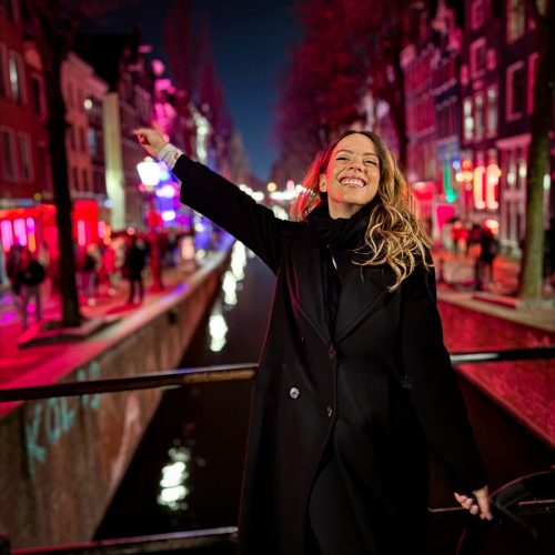 red-light-district-amsterdam-anna-trakada κορίτσι πάνω σε γέφυρα στο Άμστερνταμ με φόντο το red light district