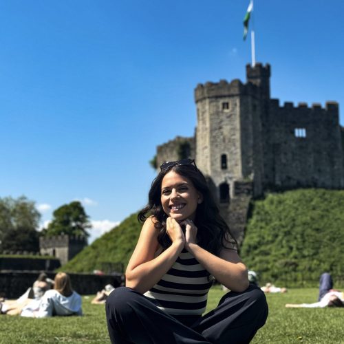 cardiff-castle-mytravelgram κορίτσι κάθεται μπροστά από το κάστρο στο Κάρντιφ της Ουαλίας
