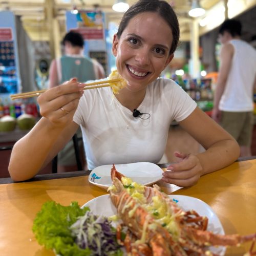 patong-lobster γυναίκα τρώει αστακό με τυρί σε αγορά τροφίμων στο Πουκέτ